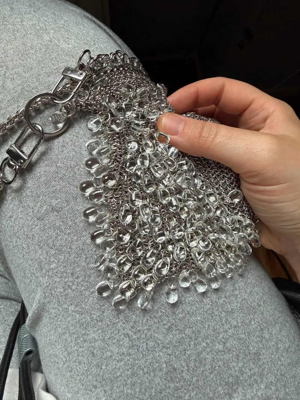 Chainmail bag held in hand, showing glass drop fringe