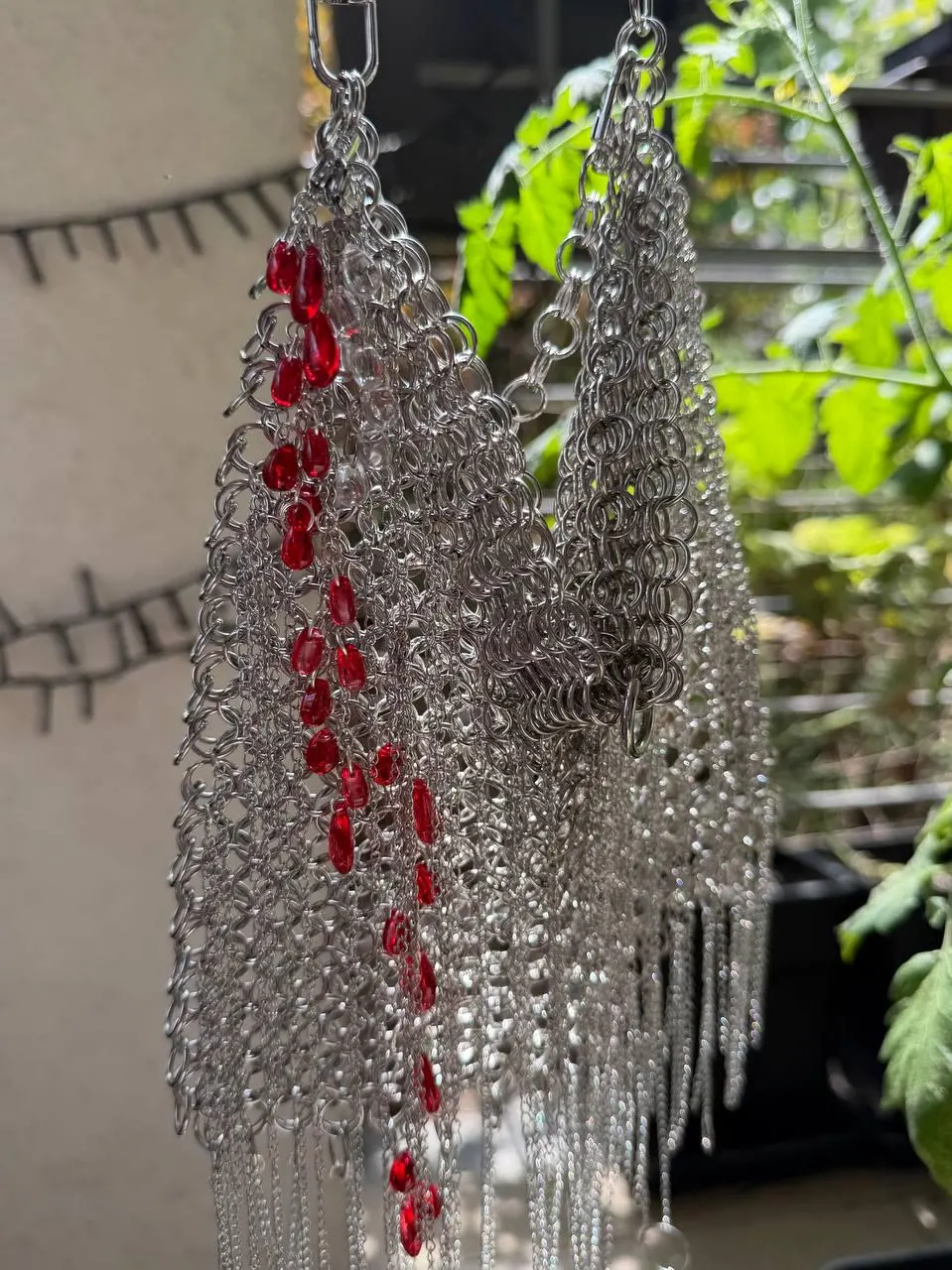 Chainmail bag hanging, showing red glass details
